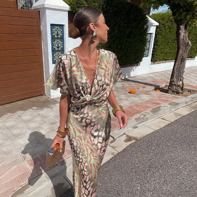 Side view of animal print wrap maxi dress with flutter sleeves and gold jewelry