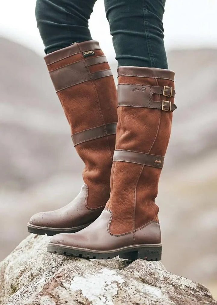 Tan leather knee-high waterproof boots with brown straps and buckle accents