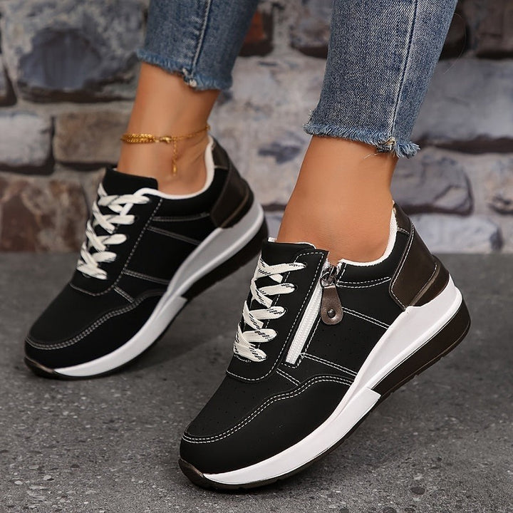 Black lace-up wedge sneakers featuring white platform sole and side zipper