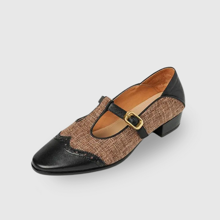 Hand holding brown leather Mary Jane shoe with tweed panel and buckle strap