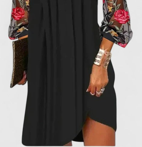 Close-up of pleated black dress with floral lace sleeve detail