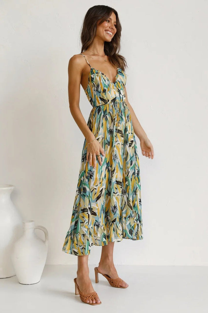 Side view of flowy abstract print midi dress with ruffle hem