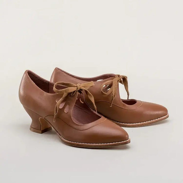 cognac brown vintage-style pumps with lace-up ties and pointed toe, studio shot