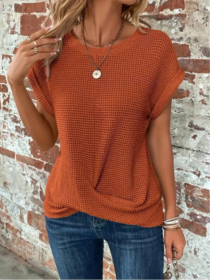 Rust orange waffle knit top with cap sleeves and knotted hem