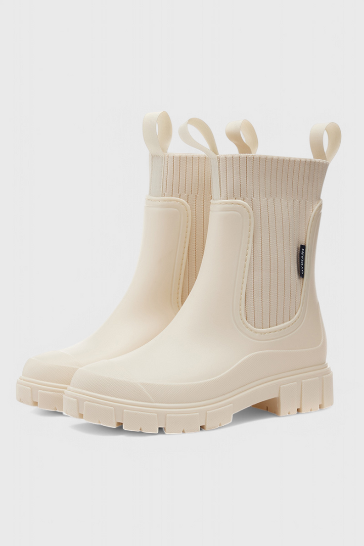 cream Chelsea rain boots with ribbed knit ankle and lug sole