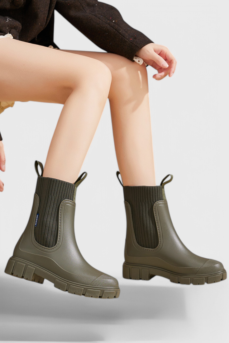 model wearing olive green Chelsea rain boots with ribbed cuff