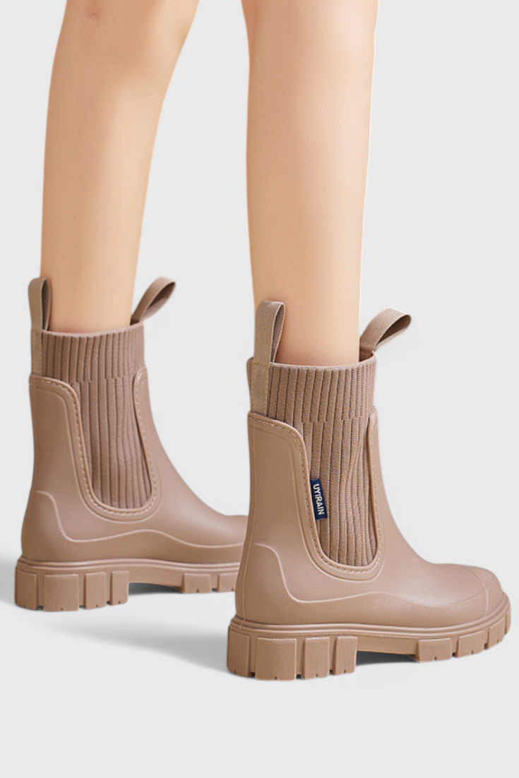 model wearing taupe Chelsea rain boots from side angle