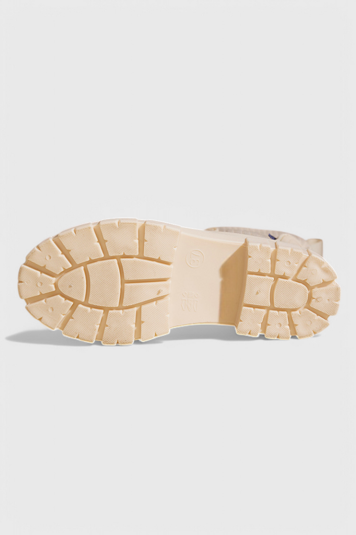 bottom view of cream rain boot showing chunky lug sole tread