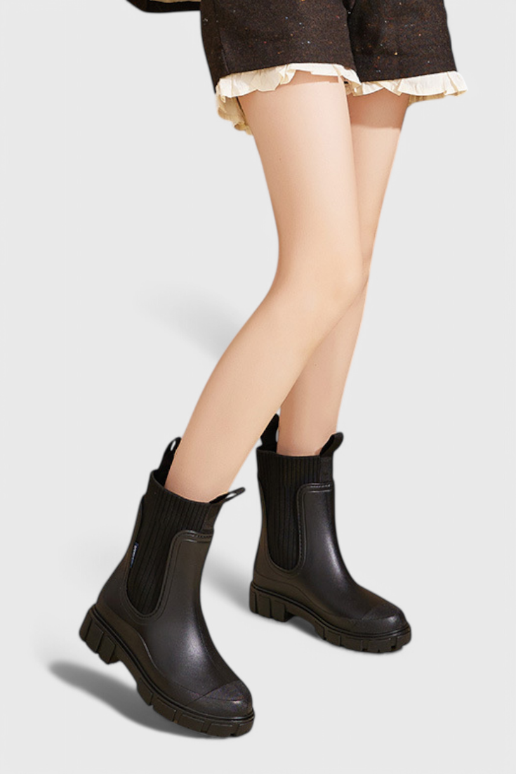 model stepping in black waterproof Chelsea boots with lug sole