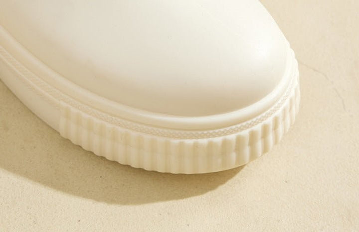 Close-up of white platform rain boot toe with ridged sole detail