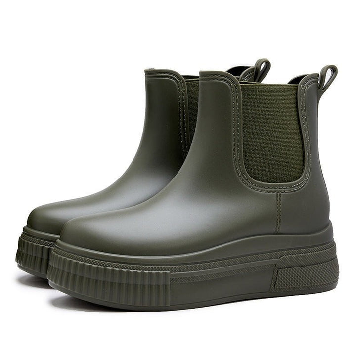Olive green ankle rain boots showing side elastic gore and ribbed platform