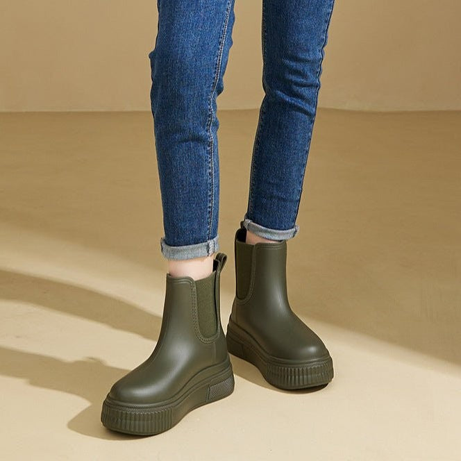 Model wearing olive green Chelsea rain boots with cuffed jeans