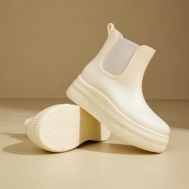 Cream Chelsea rain boots displayed with textured platform sole facing up