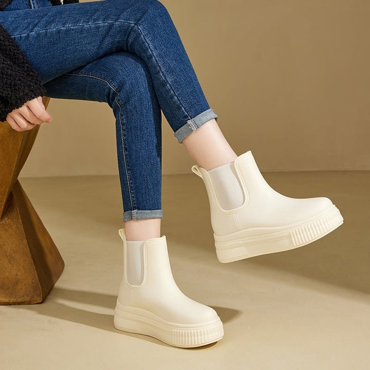 Model wearing cream white platform rain boots with rolled denim jeans