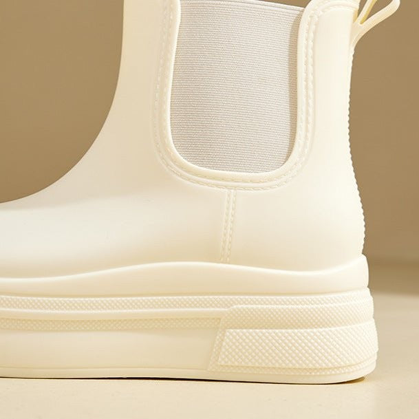 Close-up of cream Chelsea boot heel showing elastic panel and pull loop