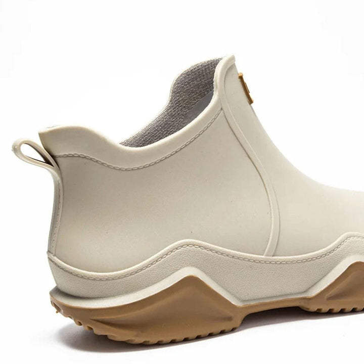 Close-up of cream ankle boot showing tan chunky sole and heel loop