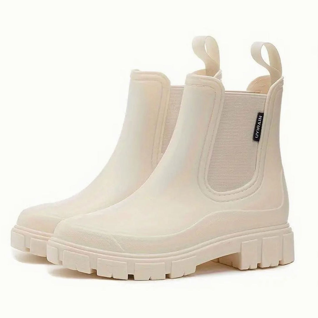 Cream Chelsea rain boots with pull-tab heel and cleated sole