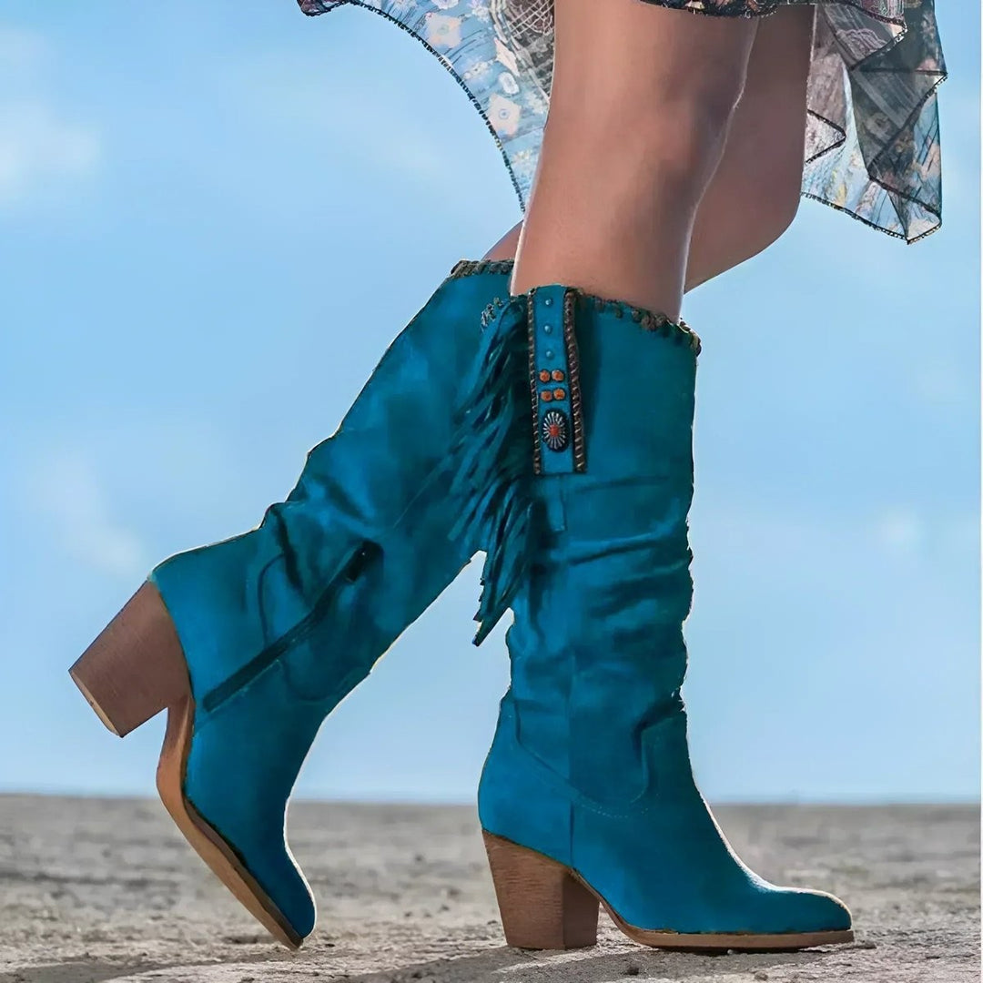 Teal suede knee-high western boots with fringe panel and stacked block heel