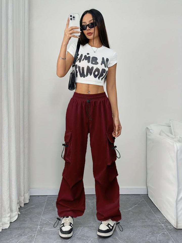 Model wearing burgundy cargo pants with white crop top and sneakers