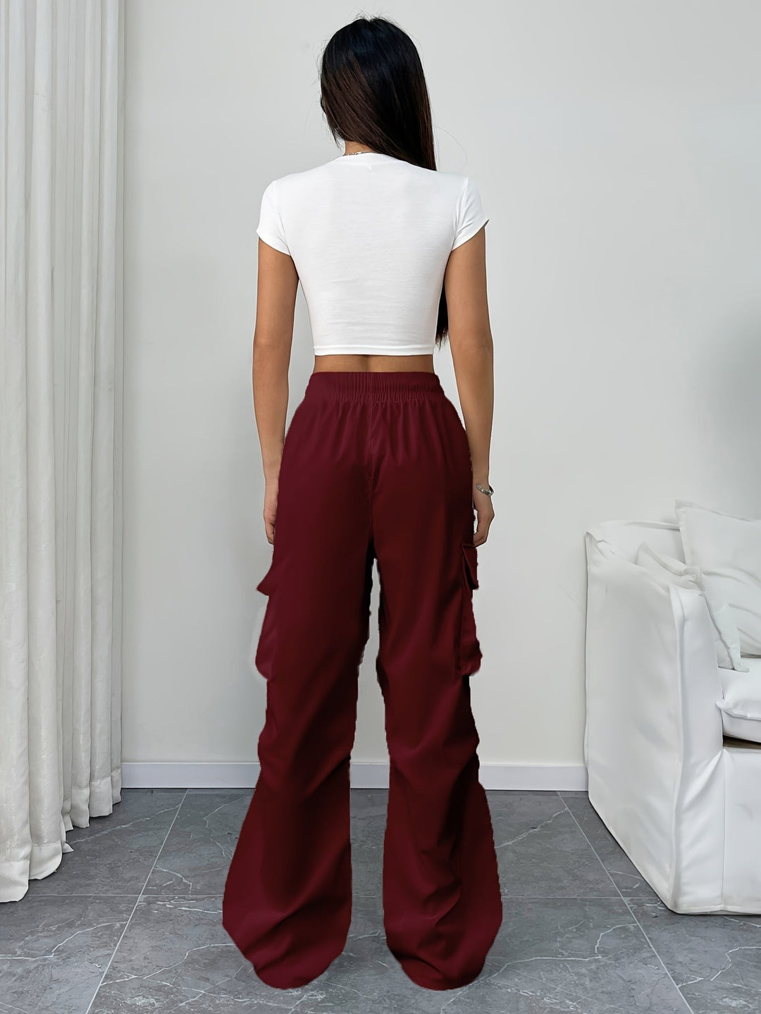 Back view of burgundy wide-leg cargo pants paired with white crop top