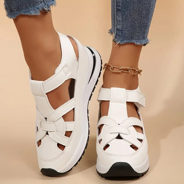 white closed-toe platform sandals with cutout straps and chunky wedge sole
