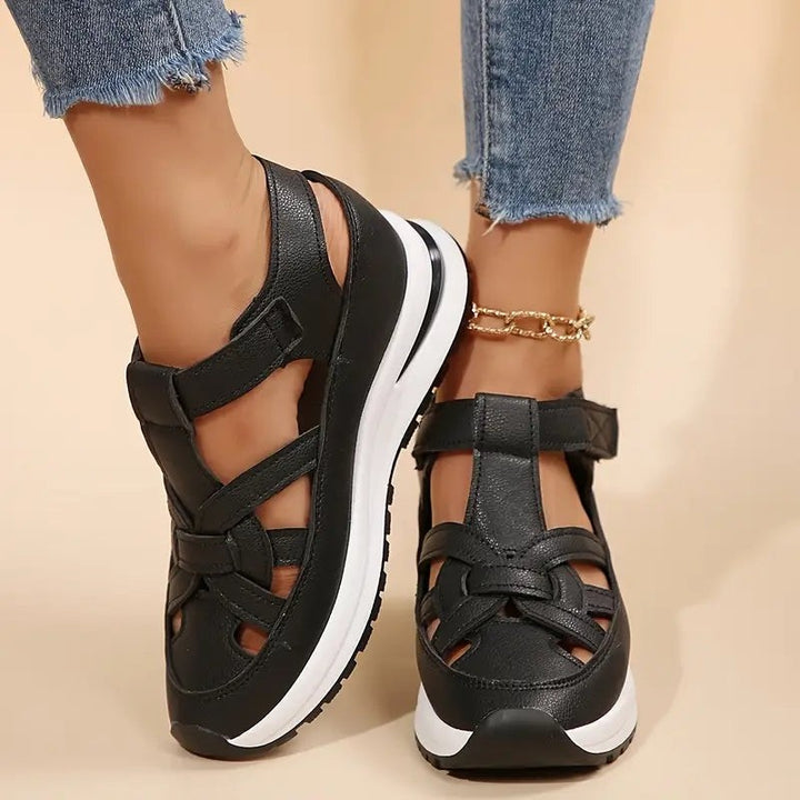 black closed-toe wedge sandals with crisscross straps and platform sole