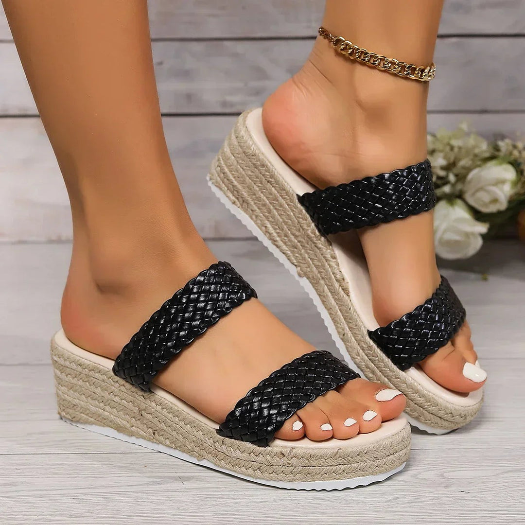 Black woven double-strap platform wedge sandal paired with gold anklet