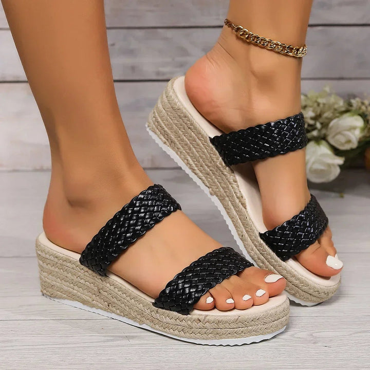 Black woven double-strap platform wedge sandal paired with gold anklet