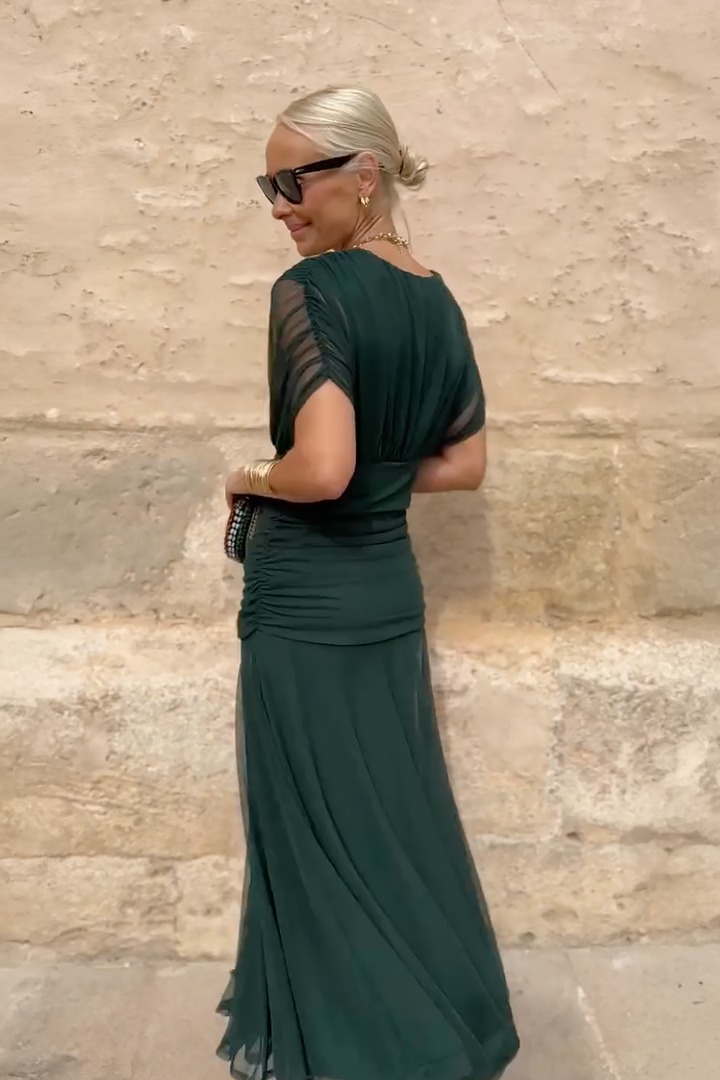 Back view of dark green maxi dress showing ruched detailing and sheer sleeves