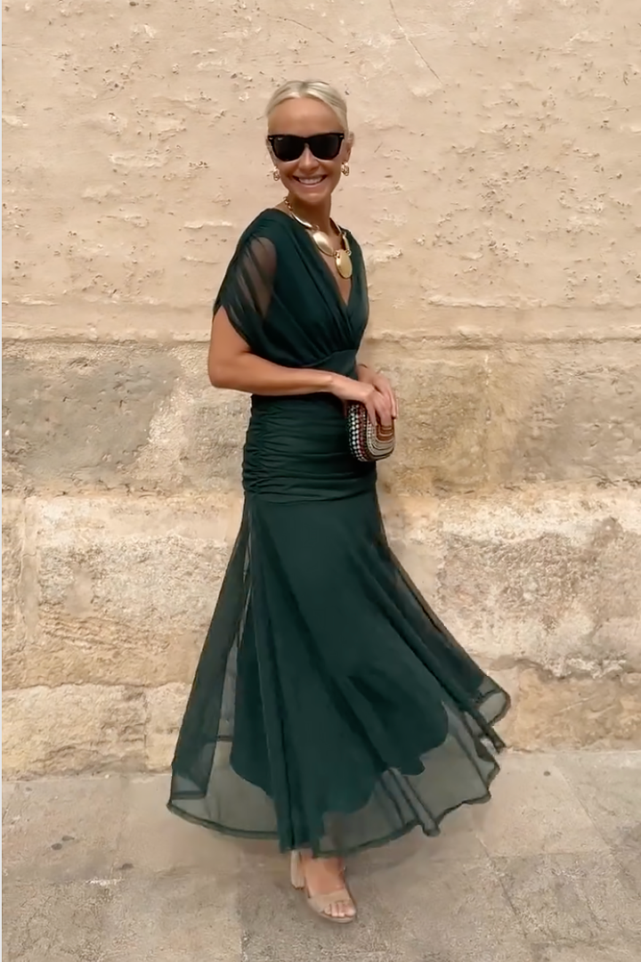 Side view of emerald mesh maxi dress with fitted waist and full skirt
