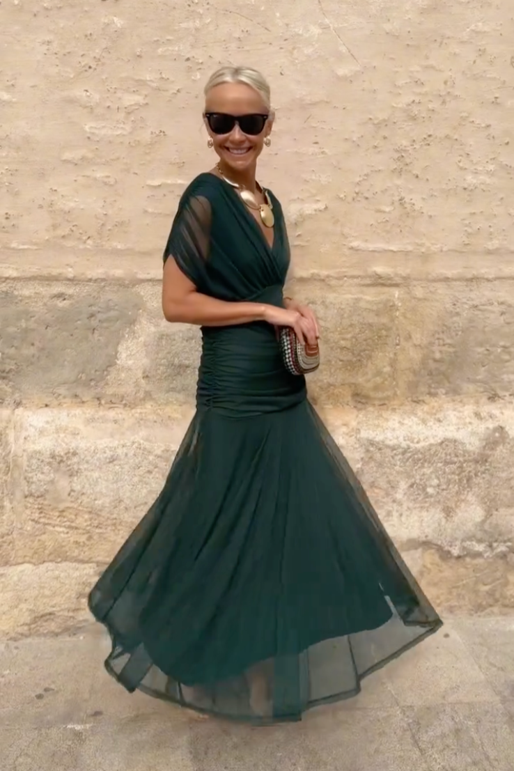 Twirling emerald maxi dress showing flowy tulle skirt and fitted ruched bodice